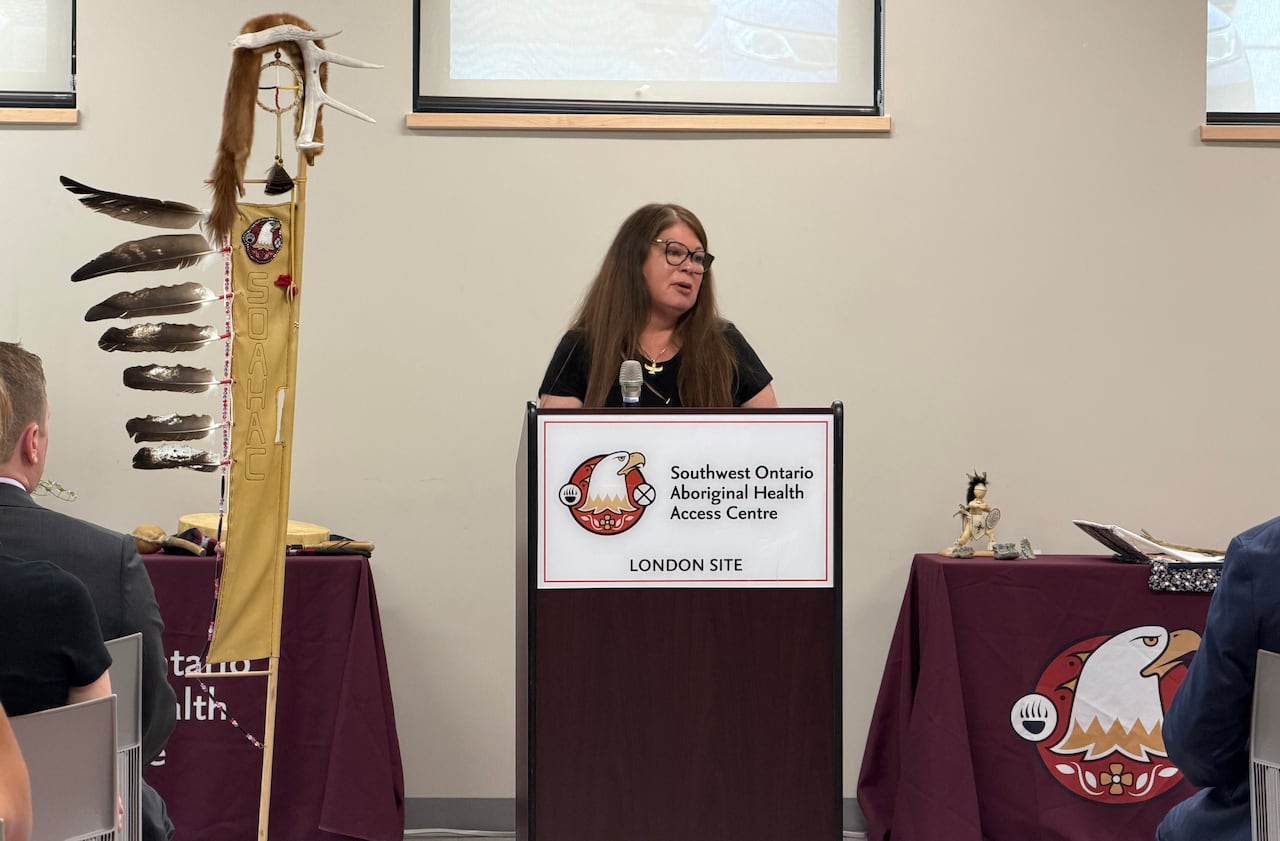 A woman speaks at a podium to a crowd