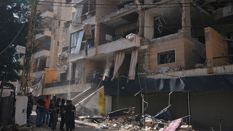 Lebanese security officers gather at the site where an Israeli airstrike hit a building in Dahiyeh, Beirut's southern suburb, Lebanon.