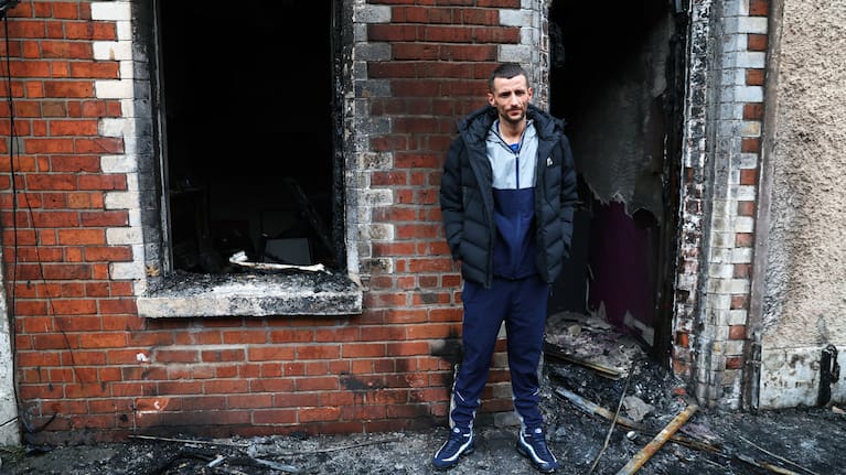 Jamie Corrie stands beside his burnt out house after rioting broke out late Tuesday, in east Belfast, Northern Ireland, Wednesday, June 10, 2026, following a stabbing incident.