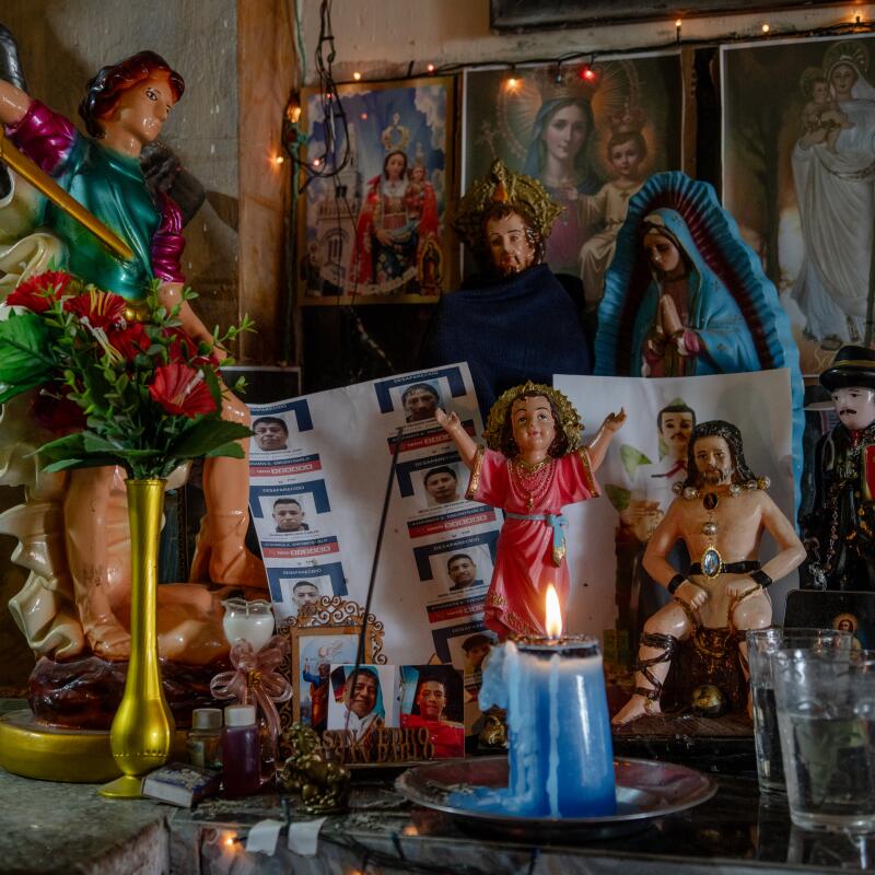 A candle burns in an altar created by Angelica Lourdes Mero Arcentales, 48, inside her home