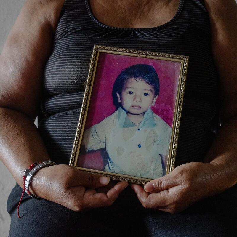 Angelica Lourdes Mero Arcentales, 48, holds a photograph of her son