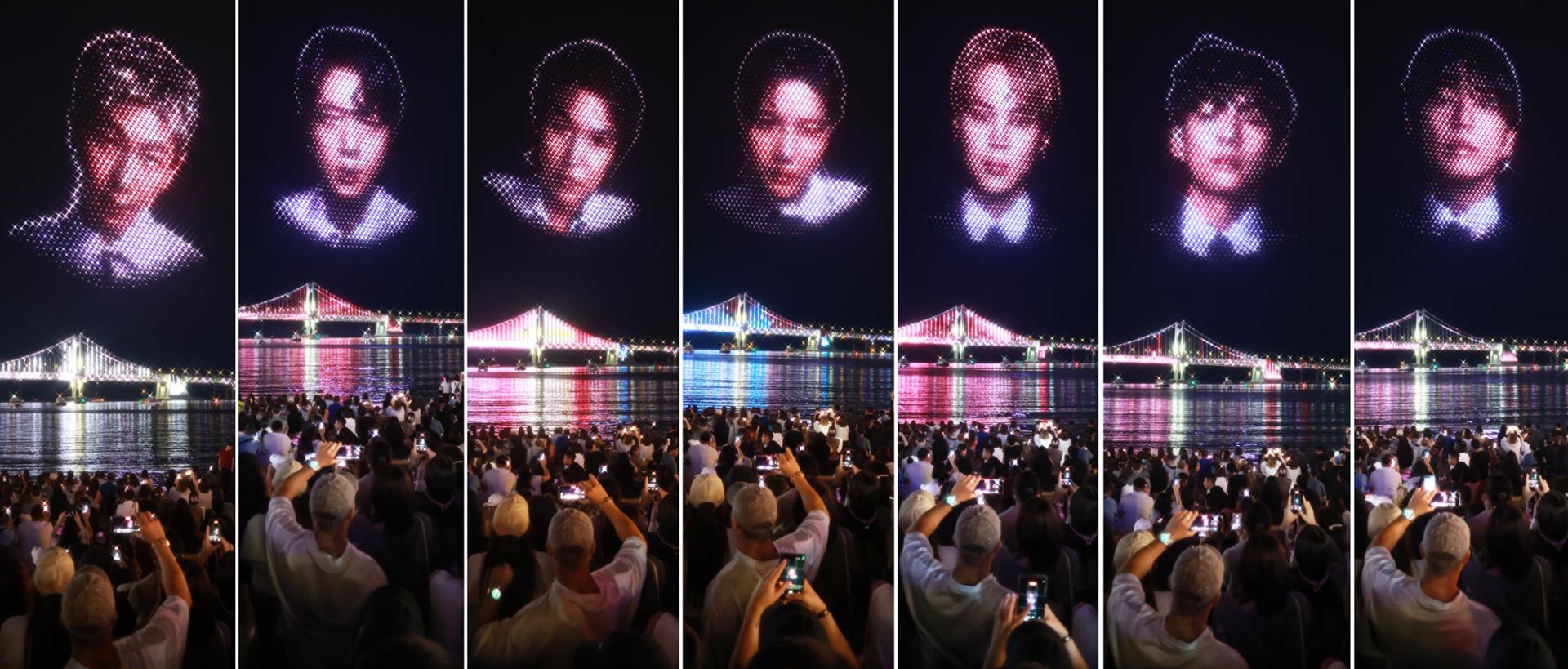 The faces of all seven BTS members light up the night sky during a special drone show commemorating the group’s Busan concert at Gwangalli Beach in Busan, Saturday. Yonhap