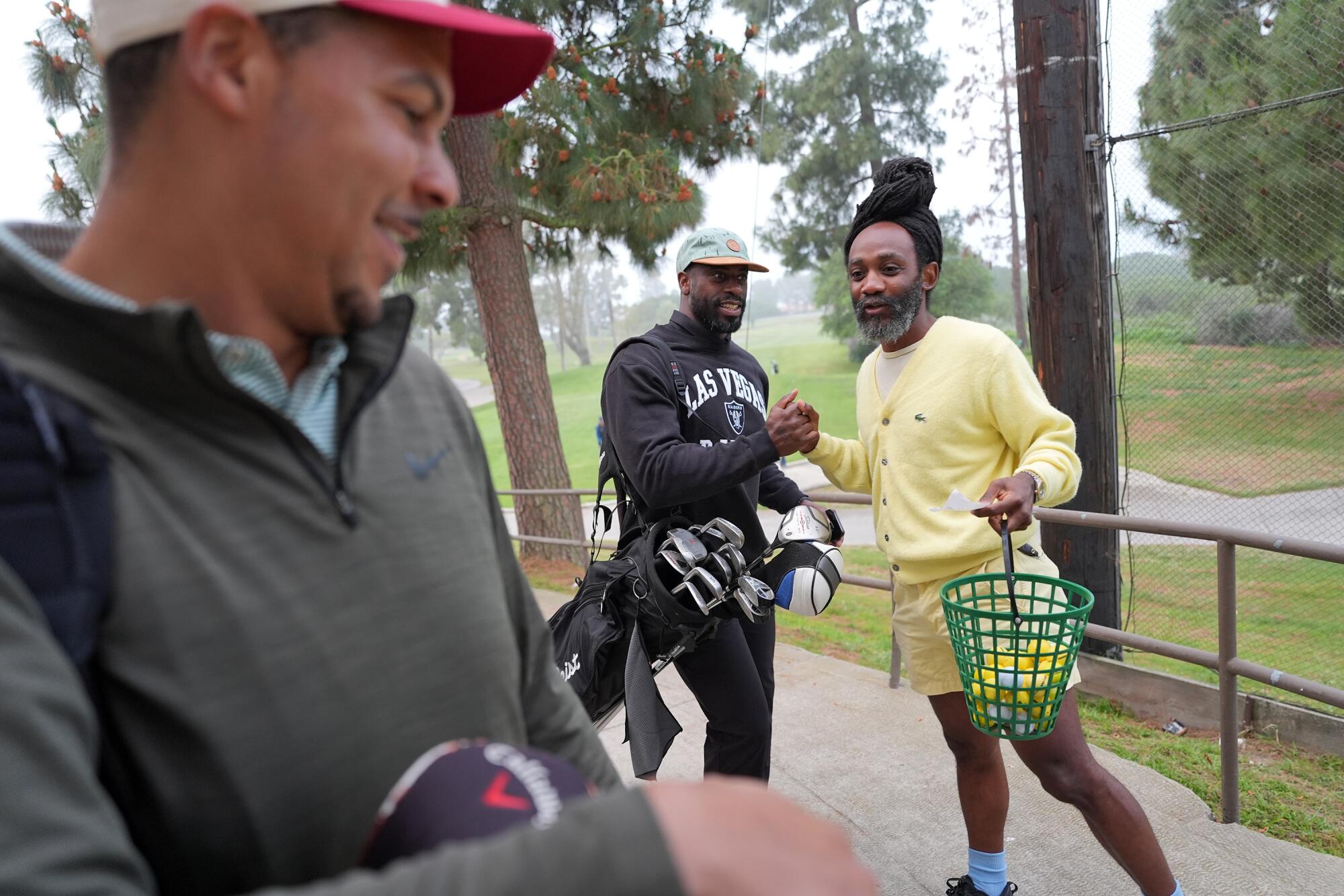 Ian Davis (right) greets Ose Akhile as Darius Ingram stands nearby