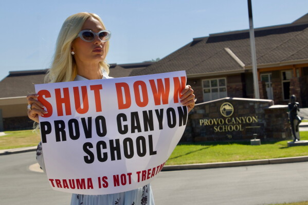 Paris Hilton protests outside the Provo Canyon School, where she says she suffered abuse as a teen, Monday, June 15, 2026, in Springville, Utah. (AP Photo/Hannah Schoenbaum)