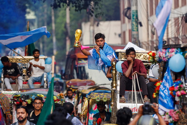 A Bangladeshi soccer fan wears an Argentina jersey and holds a replica of the FIFA World Cup trophy in support of the team competing at the 2026 FIFA World Cup during a rally in Dhaka, Bangladesh, Tuesday, June 16, 2026. (AP Photo/Rajib Dhar)