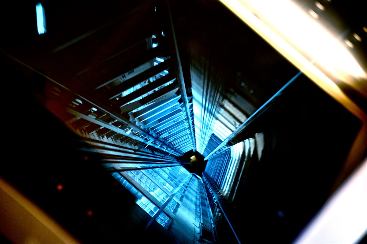 An empty elevator shaft illuminated by blue light.