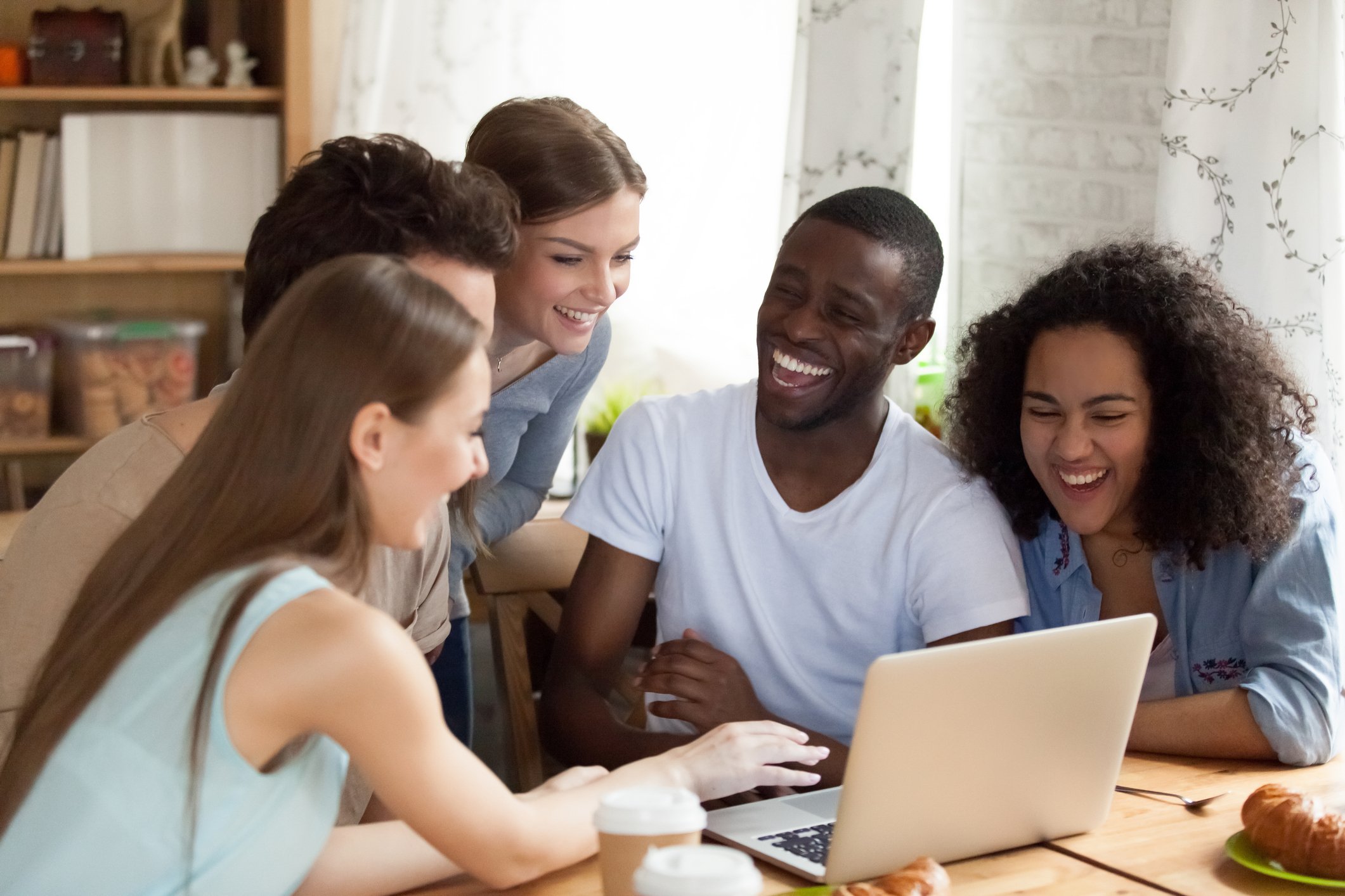 Investors gather around a laptop to look at something.