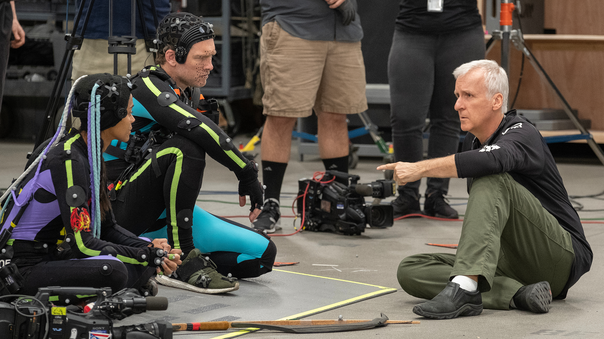 Zoe Saldaña, Sam Worthington, and James Cameron behind the scenes of Avatar: Fire and Ash