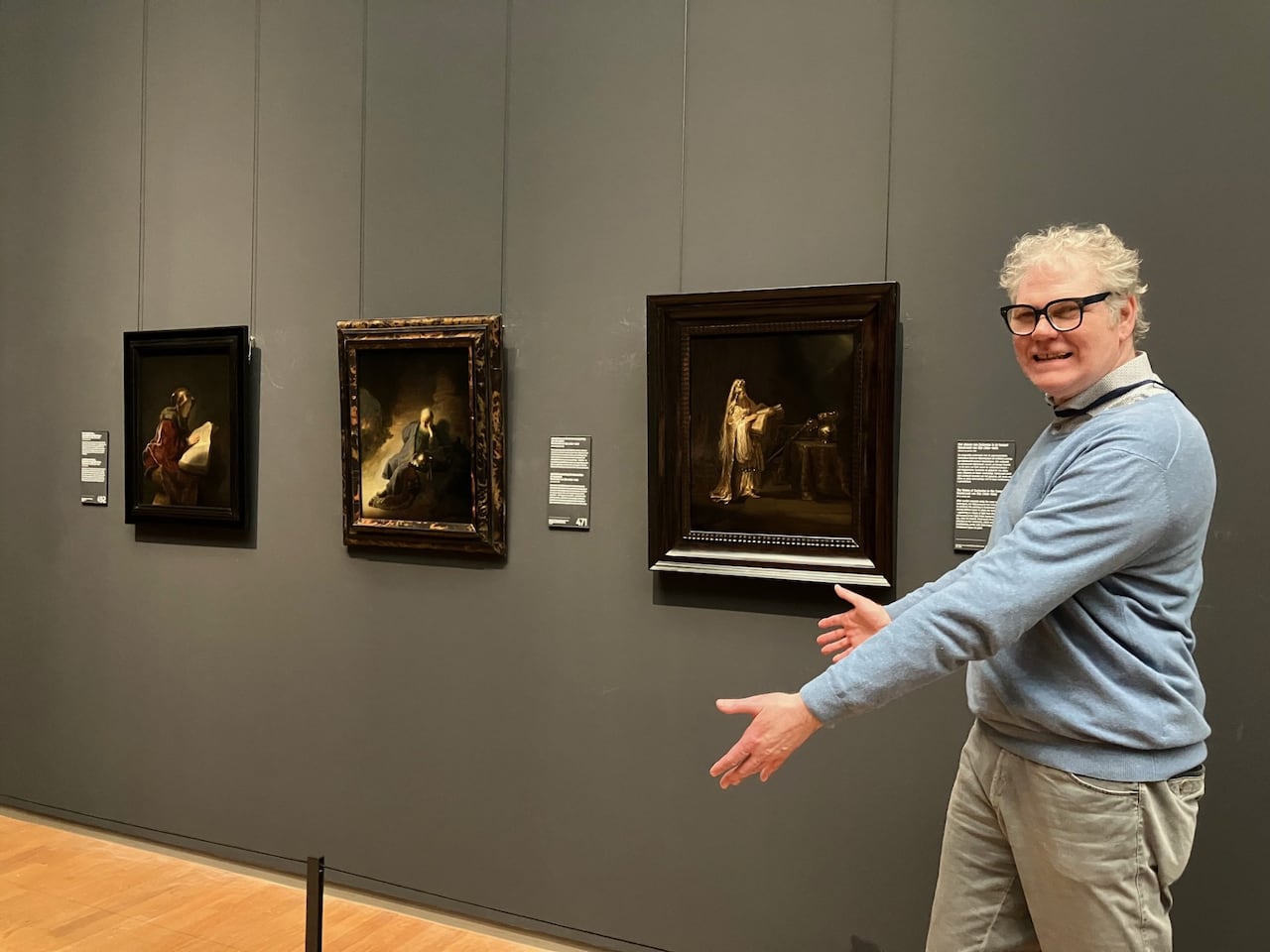 picture of man in front of paintings