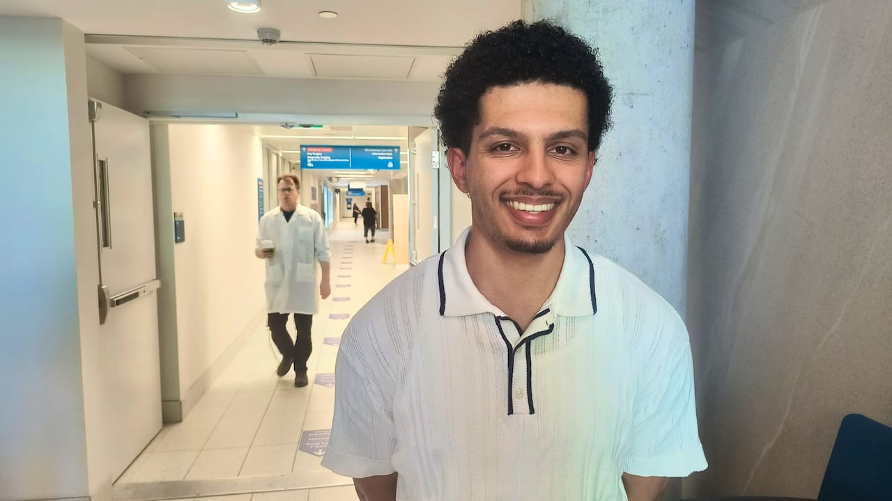 A man smiles in a hospital hallway