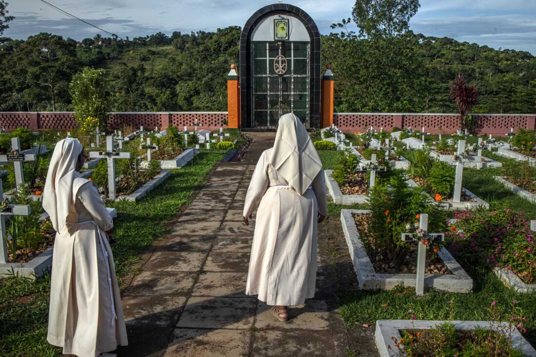 Sister Jean Francis, Superior General of the Little Sisters of St Francis, walks alongside another nun past a cemetery within the congregation’s premises in Nkokonjeru, Uganda, on May 11, 2026. The cemetery is where members of the congregation are laid to rest. The Little Sisters of St Francis, who have served in schools, clinics and communities across Uganda for decades, are now also focusing on care for aging and retired sisters, many of whom require increasing medical and end-of-life support after years of service.