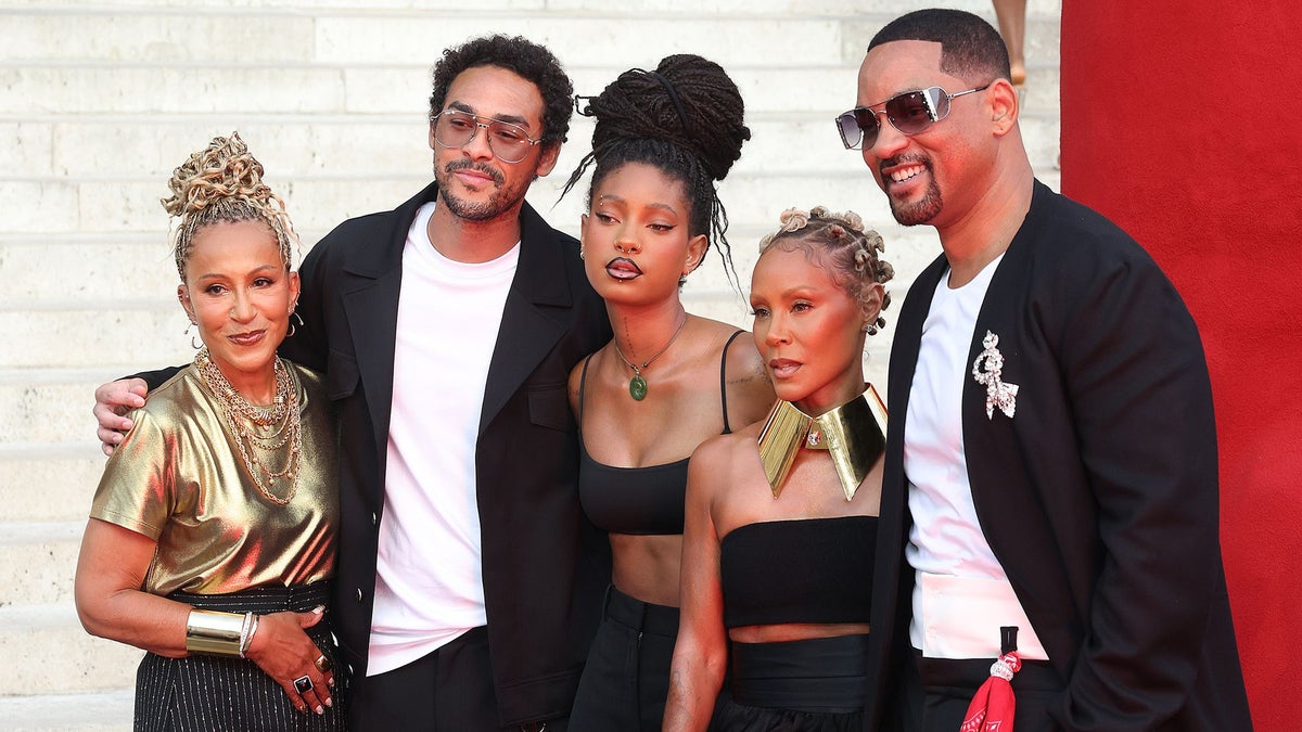 Will Smith and Jada Pinkett Smith pose in coordinated looks with Willow and Trey Smith to support Jaden Smith at Paris Fashion Week
