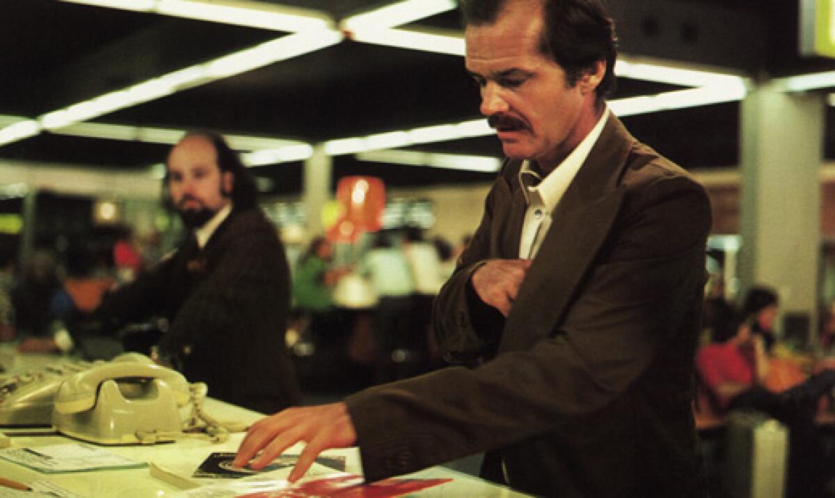 A man sits at a desk in an open office.