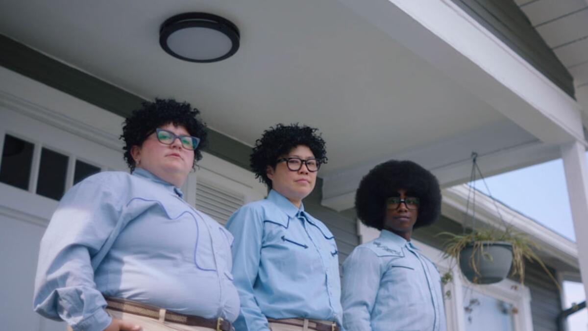 Several people dress in matching blue button-downs and thick glasses.