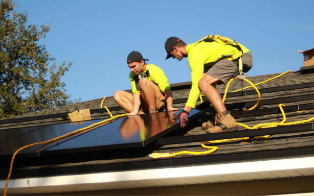 Workers installing rooftop solar.