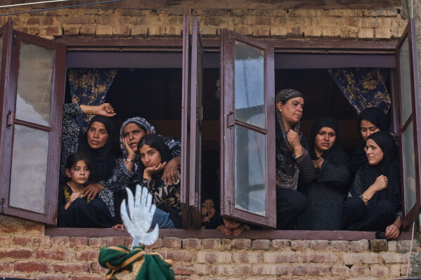 Kashmiri Shiite Muslim women watch an Ashura procession in Srinagar, Indian controlled Kashmir, Friday, June 26, 2026. (AP Photo/Dar Yasin)