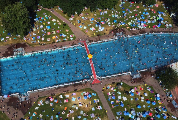 Hundreds of people gather in a public pool in Frankfurt, Germany, on a hot Saturday, June 27, 2026. (AP Photo/Michael Probst)