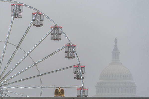 The U.S. Capitol is seen through fog behind the ferris wheel at the Great American State Fair on the National Mall, Sunday June 28, 2026, in Washington. (AP Photo/Jen Golbeck)