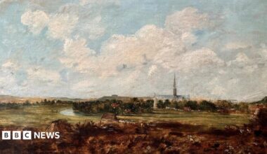 An oil painting showing blue sky with clouds and a cathedral and spire in the distance. Trees, fields and a river bend are painted in front of the cathedral.