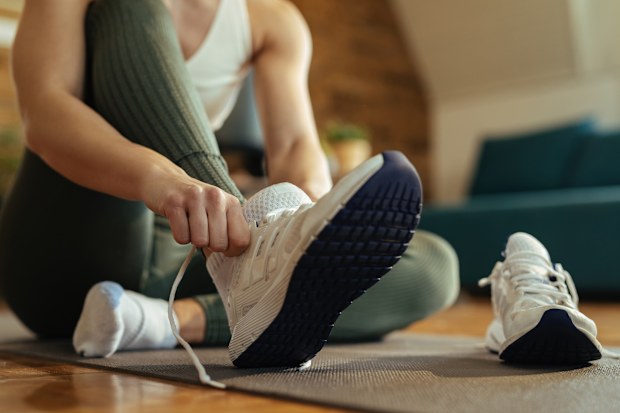 Woman putting on sneakers