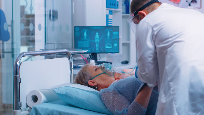 A nurse attends to an elderly patient in a hospital bed, addressing things that happened with patients.