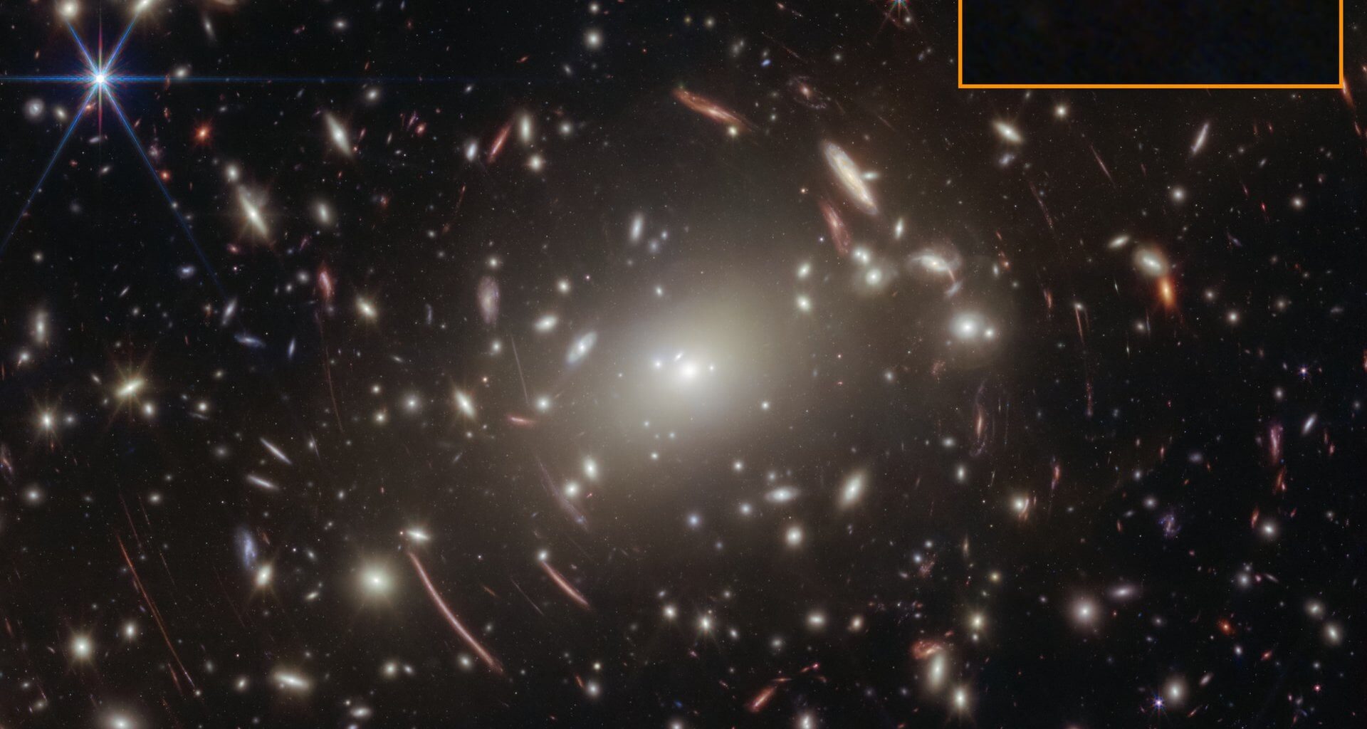 Webb's view of galaxy cluster Abell S1063, whose gravity magnifies the little red dot GLIMPSE-17775 (boxed, lower right). The curved red arcs are lensed background galaxies (Credit : NASA, ESA, CSA, Vasily Kokorev (UT Austin); Image Processing: Alyssa Pagan (STScI))