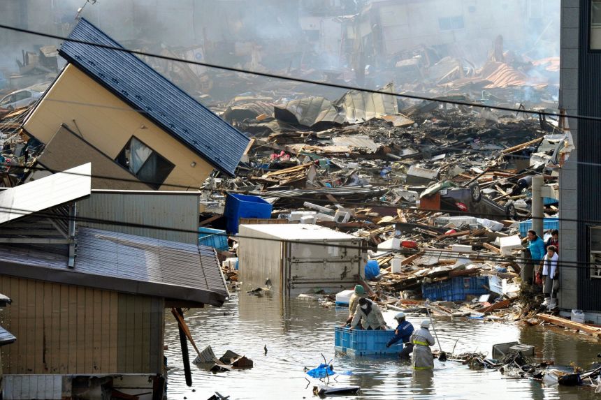 People in a floating container are rescued from a building following the earthquake and tsunami in Miyagi Prefecture, northeastern Japan.
