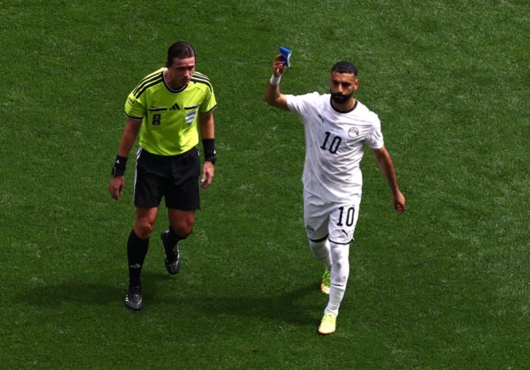Soccer Football - FIFA World Cup 2026 - Group G - Belgium v Egypt - Seattle Stadium, Seattle, Washington, U.S. - June 15, 2026 Egypt's Mohamed Salah holds up the captains armband as he is substituted as referee Ramon Abatti looks on REUTERS/Lee Smith