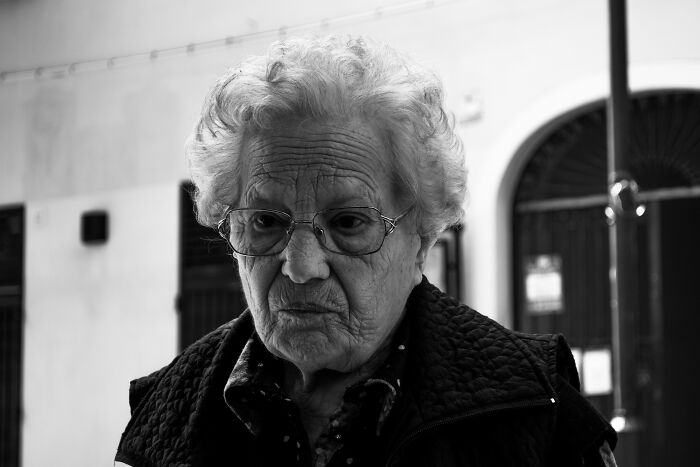 Elderly woman with glasses looking down, representing unexplained things that happened with patients.