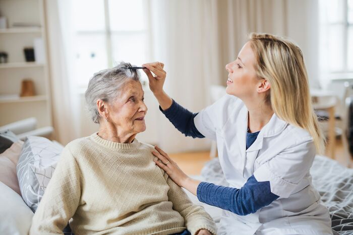 A nurse cares for an elderly female patient, combing her hair. Nurses sometimes have no explanation for patient events.