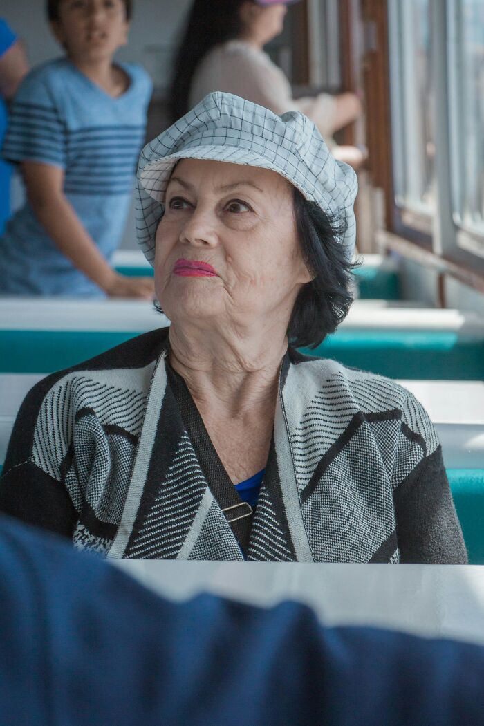 An older woman with a patterned hat and cardigan looks thoughtful. Nurses encounter mysterious patient situations.