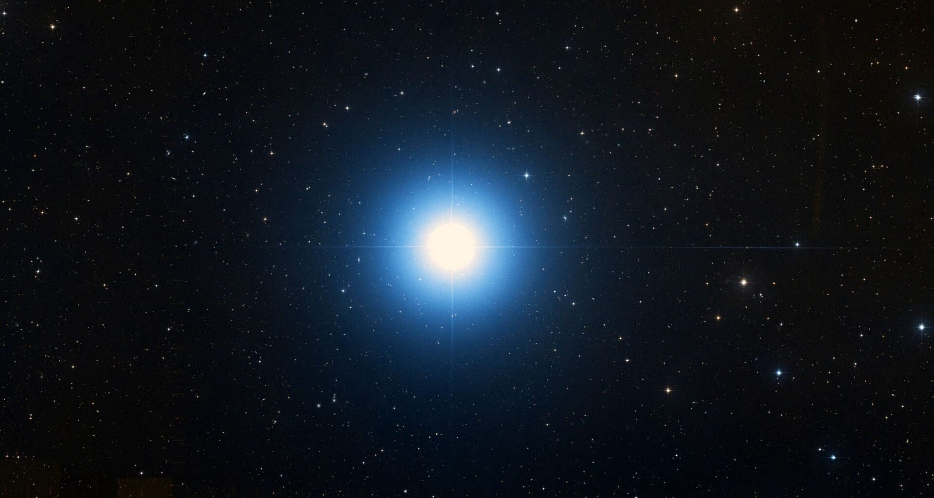 A bright blue star is pictured shining in a black sky surrounded by lesser stars.