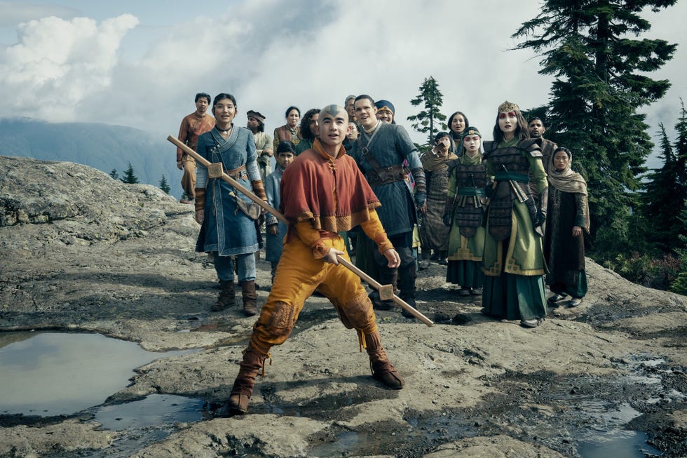 cast of netflix's avatar the last airbender season 2 standing together against a rocky back drop with aang positioned at the front.