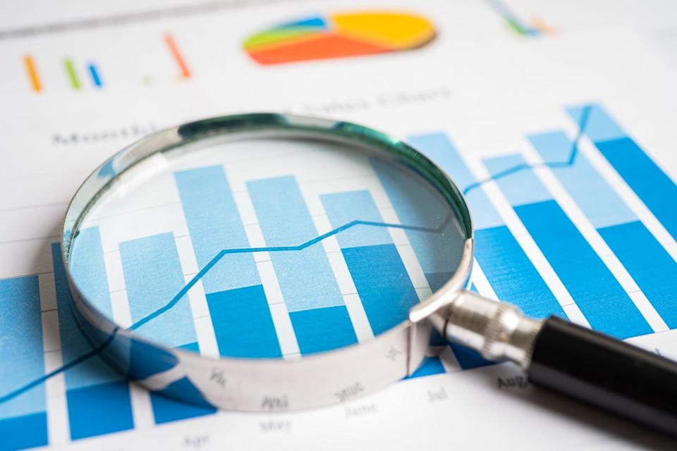 A magnifying glass hovers over a bar chart.