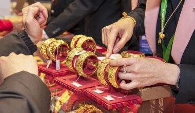 A sales representative shows a piece of gold jewelry at an expo in Guangzhou, South China