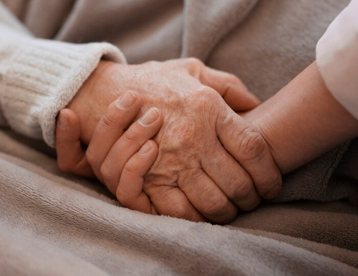 Close-up of a nurse holding the hand of an elderly patient, highlighting the things that happened with patients.