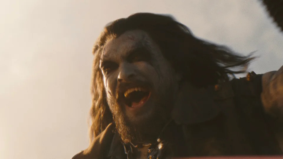 Lobo smiling with mouth wide open while riding his motorcycle in Supergirl