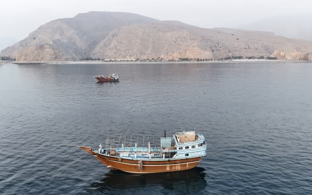 This aerial photograph shows boats anchored off Oman’s northern Musandam Peninsula near the Strait of Hormuz on June 27, 2026. Iran launched attacks on US sites in the Gulf in response to American strikes on the country, state media said on June 27, after Washington accused Tehran of attacking one of its cargo ships in the Strait of Hormuz. The trading of fire raised questions about efforts to keep the crucial waterway open while Washington and Tehran negotiate a final settlement to a war that began on February 28 with US and Israeli strikes on Iran. (Photo by AFP) /