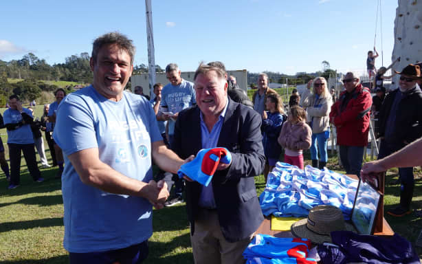 Russell captain Taine Randell gets his jersey from All Black legend Grahame Thorne.