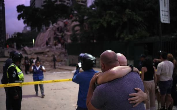Men react in front of a collapsed building following an earthquake in Caracas on June 24, 2026. A magnitude 7.1 earthquake struck Venezuela on Wednesday, the United States Geological Survey (USGS) reported, triggering panic in Caracas, according to AFP journalists. The tremor, which was followed by several aftershocks, was also felt in Colombia. (Photo by Manaure QUINTERO / AFP)