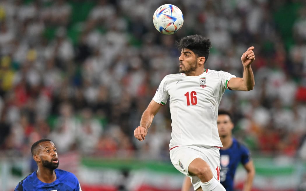 Iran's midfielder #16 Mehdi Torabi heads the ball during the Qatar 2022 World Cup Group B football match between Iran and USA at the Al-Thumama Stadium in Doha on November 29, 2022. (Photo by Glyn KIRK / AFP)