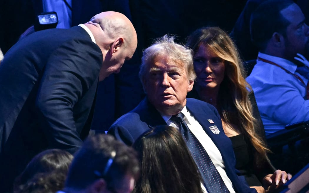 (L/R) UFC President Dana White speaks with US President Donald Trump alongside First Lady Melania Trump as they attend the
