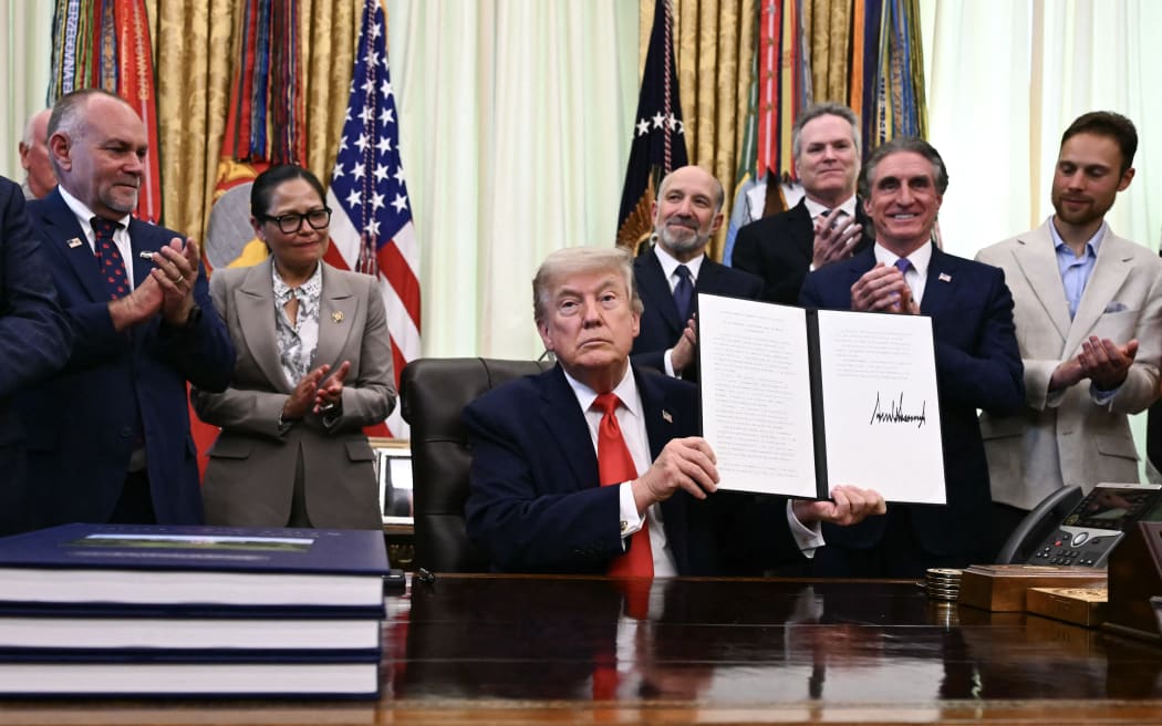 US President Donald Trump displays a proclamation on