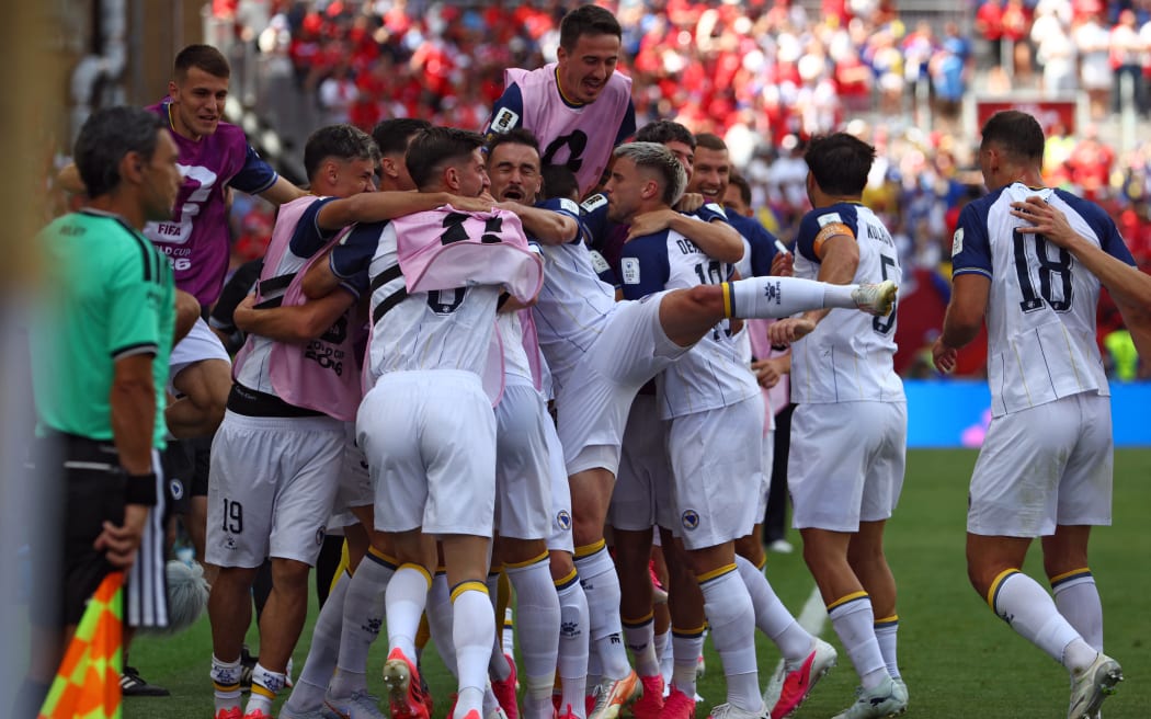 Bosnia-Herzegovina's forward #25 Jovo Lukic (hiddden) is is congratulated by teammates after scoring a goal during the 2026 World Cup Group B football match between Canada and Bosnia and Herzegovina at the Toronto Stadium in Toronto on June 12, 2026. (Photo by Cole Burston / AFP)