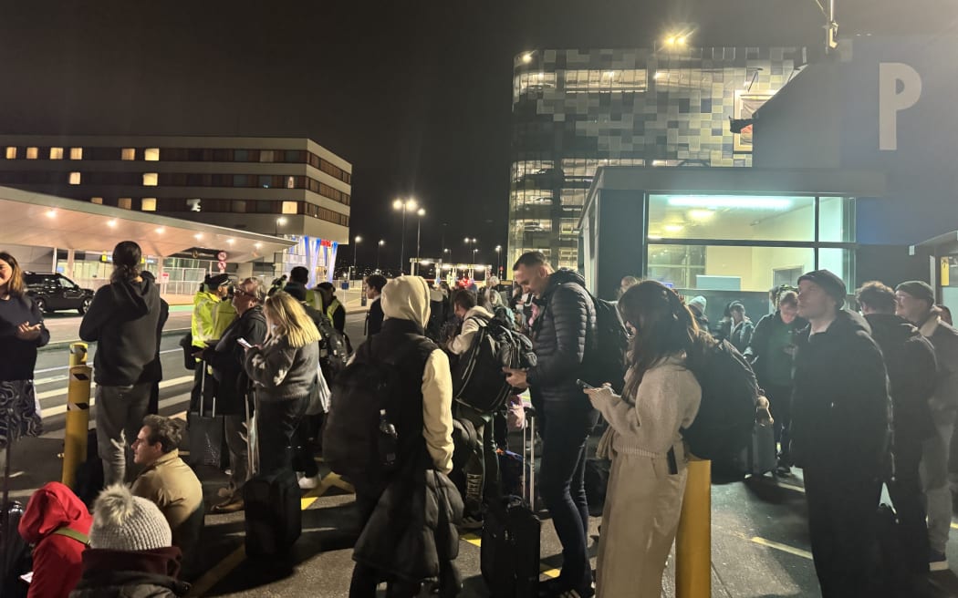 People evacuated from Wellington Airport wait in the car park on 12 June, 2026.