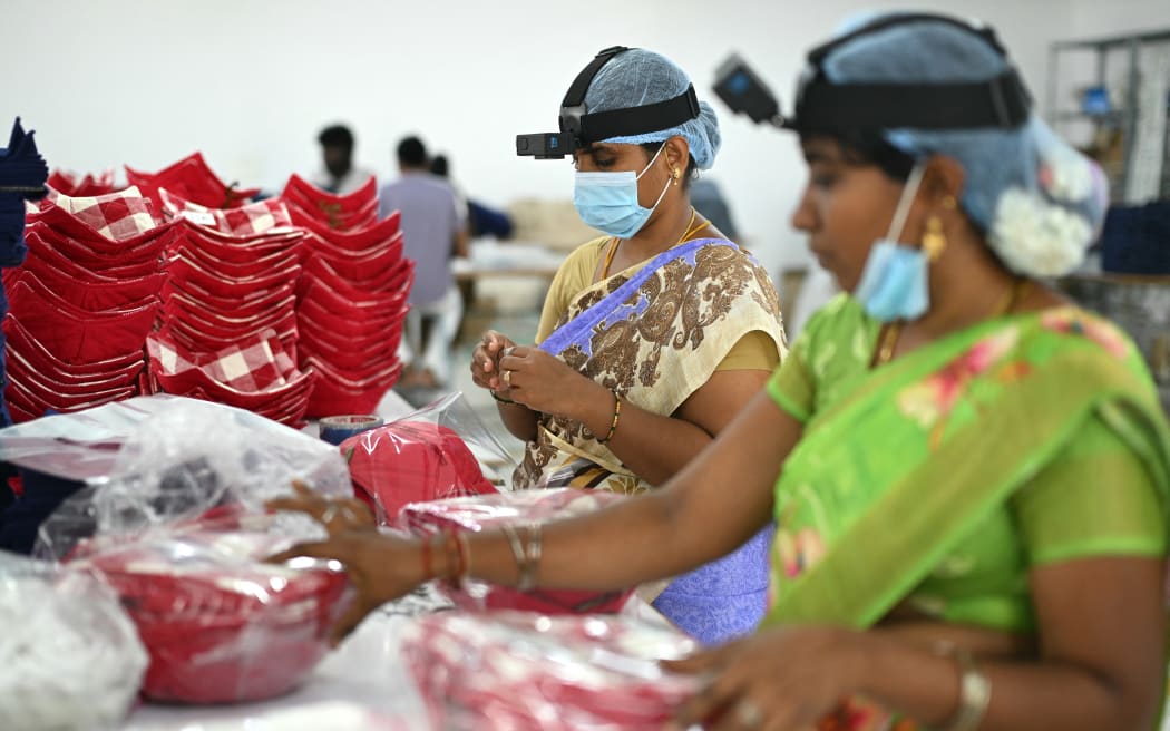 This photograph taken on May 13, 2026 shows workers wearing GoPro cameras on their heads recording actions through motion capture inside a factory in Tamil Nadu's Karur district. Developers think feeding first-person footage, called "egocentric data", into specialised AI models will help robots copy humans. The humanoid robot market is booming, with investment bank Morgan Stanley predicting there could be over a billion in use by 2050, mostly for industrial and commercial purposes. In India, the emerging field of spatial AI is providing new employment -- for now. (Photo by R.Satish BABU / AFP)