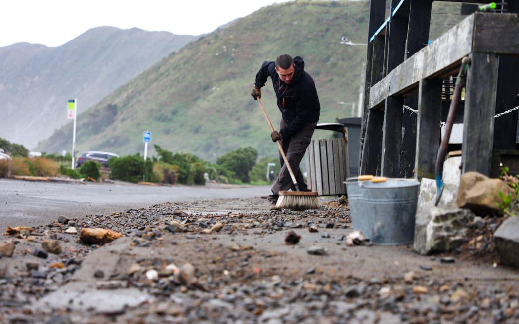 Max Gnojczak sweeping storm debris out front of Beach House & Kiosk