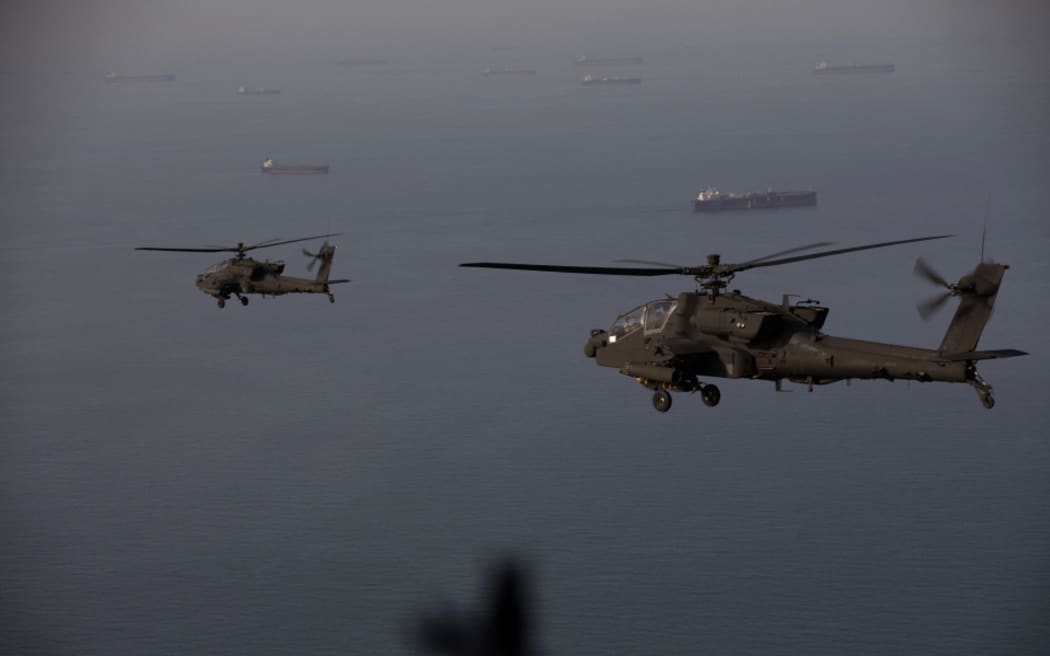 This handout photo released by US Central Command via their X account (@CENTCOM) on April 18, 2026 shows AH-64 Apaches flying above the Strait of Hormuz during a patrol on April 17, 2026. Iran's military declared the Strait of Hormuz closed again on April 18, prompting ships to abandon attempts to transit and President Donald Trump to warn Tehran against trying to "blackmail" the United States. On April 17, Tehran had declared the strait, which usually carries a fifth of the world's oil and liquefied natural gas, open after a ceasefire was agreed in Israel's war with Iran's ally Hezbollah in Lebanon. (Photo by US Central Command (CENTCOM) / AFP) / RESTRICTED TO EDITORIAL USE - MANDATORY CREDIT "AFP PHOTO / US CENTRAL COMMAND " - HANDOUT - NO MARKETING NO ADVERTISING CAMPAIGNS - DISTRIBUTED AS A SERVICE TO CLIENTS