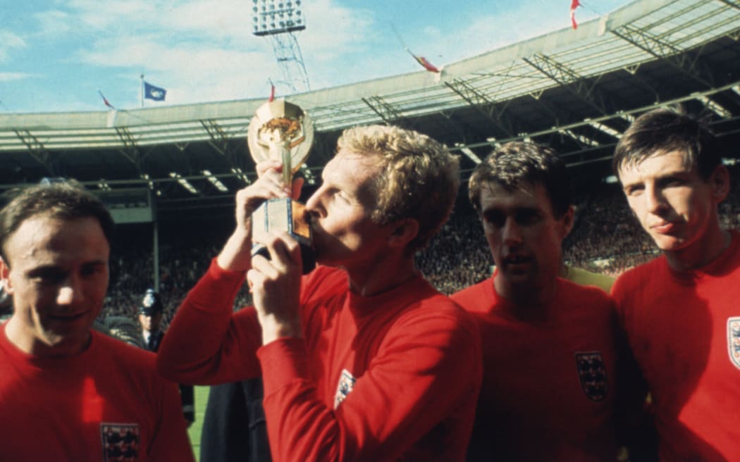 England captain Bobby Moore kissing the Jules Rimet trophy as the team celebrate winning the 1966 World Cup final against Germany at Wembley Stadium. His team mates are, left to right, George Cohen, Geoff Hurst and Martin Peters, 30th July 1966. (Photo by Hulton Archive/Getty Images)