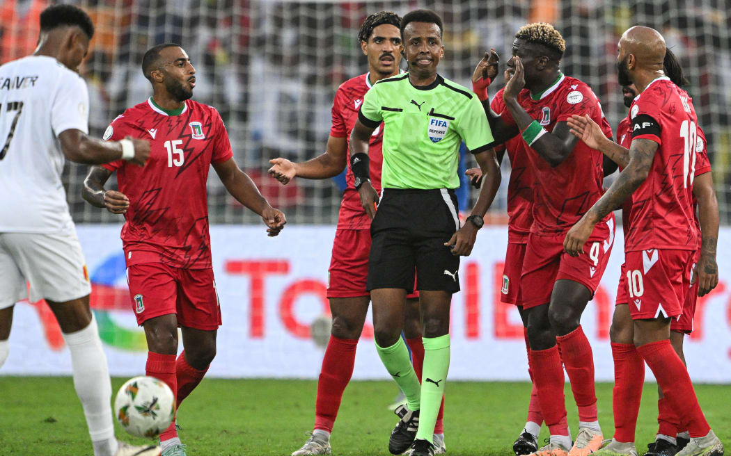 (FILES) Equatorial Guinea's midfielder #4 Fede Bikoro (2R) speaks with Somali referee Omar Abdulkadir Artan (C) during the Africa Cup of Nations (CAN) 2024 round of 16 football match between Equatorial Guinea and Guinea at the Alassane Ouattara Stadium in Ebimpe, Abidjan, on January 28, 2024. Award-winning Somali referee Omar Artan, set to be the first from his country to officiate at the World Cup, was denied entry to the United States, a sports ministry official told AFP on June 8, 2026.
"Denying him entry to the United States and preventing him from officiating scheduled matches harms not only him personally but also undermines football's commitment to fairness, merit, and the spirit of fair play," Ciise Aden Abshir, a senior advisor to Somalia's Ministry of Youth and Sports and a former national team captain, told AFP. (Photo by Issouf SANOGO / AFP)
